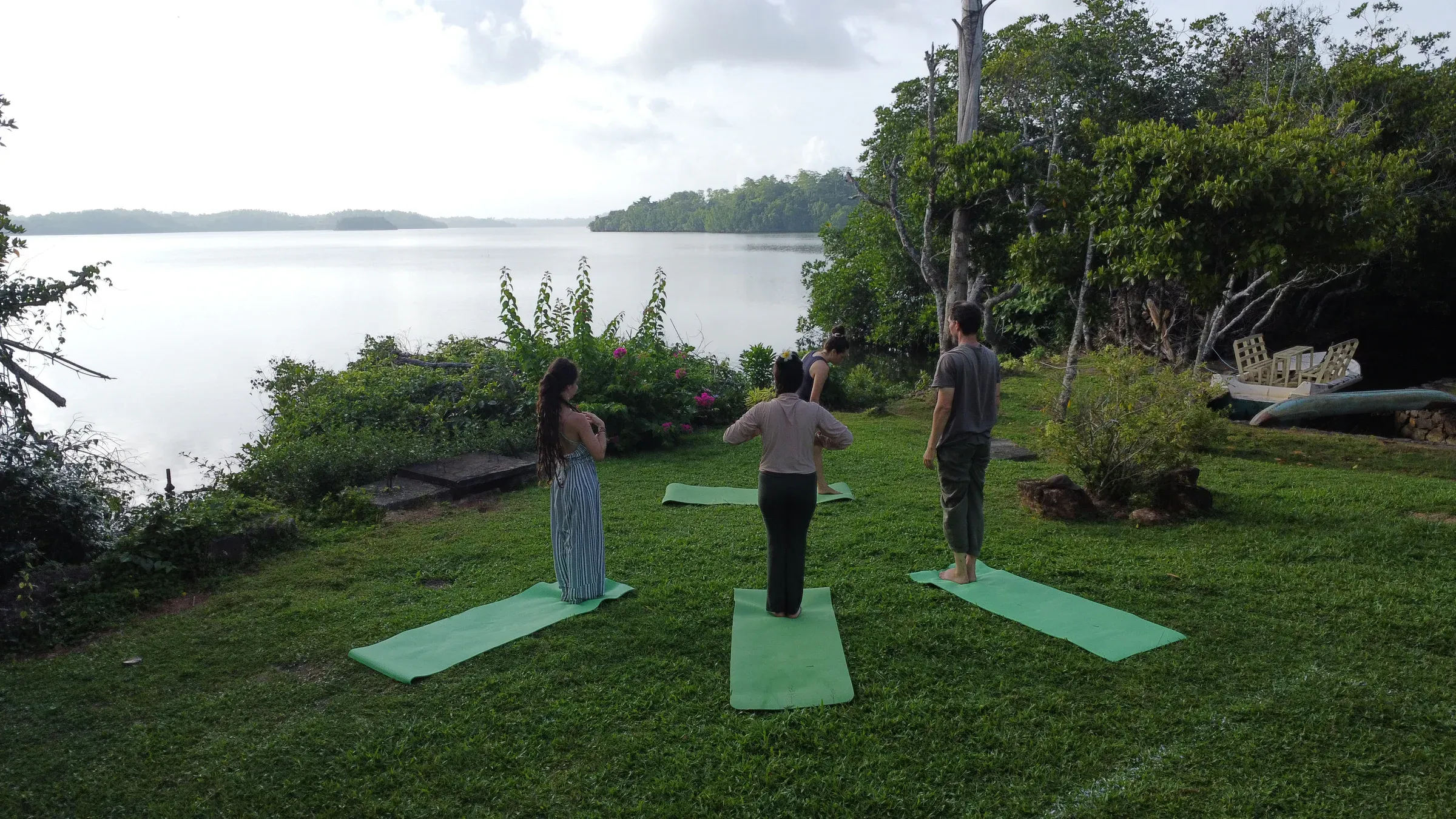 Gäste beim Yoga auf Matten auf der Wiese am Koggala-See